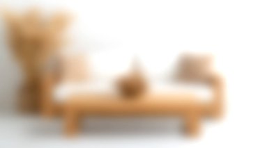 Şık, minimalist bir oturma odası. Yastıklı ahşap bir kanepe, şık bir kahve masası ve süs bitkileri var. Huzurlu bir estetik için mükemmel..