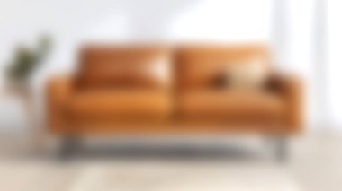 Dekoratif yastıkla süslenmiş modern kahverengi deri bir kanepe. Parlak bir oturma odasına yerleştirilmiş, konforu ve tarzı davet eden..