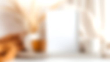 Boş bir çerçeve, sıcak tekstil ve doğal elementlerin sergilendiği çarpıcı bir ev dekoru sahnesi, rahat ve davetkar bir ortamda sergilenmek için mükemmel..