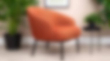 Sıcak turuncu aksanlı sandalye modern bir oturma odasına sıcaklık ve tarz katar. Yeşillik ve şık bir masa ile tamamlanır. Rahatlama ve estetik geliştirme için mükemmel..