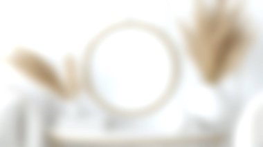 Işığı yansıtan ve doğal dekoratif elementlerle eşleştirilmiş yuvarlak aynanın yumuşak bulanık bir görüntüsü. Ev dekorasyonu kavramları ve iç mimari ilham için ideal.