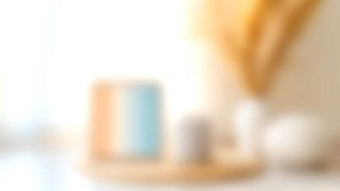 Dekoratif unsurların basitlik ve sıcaklığı vurguladığı, modern ve rahat bir ortamda kahve fincanı sergilenen yumuşak bulanık bir görüntü. Yaşam tarzı temaları için ideal.