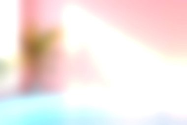 Yumuşak pembe duvarlar ve şık bir tencerede yeşil bir bitki barındıran, ışığın ve gölgenin etkileşimini aydınlatan sakin bir iç mekan..