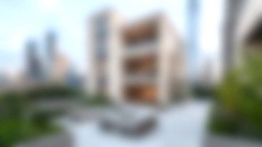 Bu resim, eşsiz mimari unsurları ve çevreleyen yeşillikleri vurgulayan kentsel bir çevrede yer alan modern bir yerleşim binasını gösteriyor..