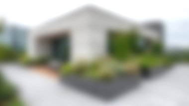 Bu şehir ortamında modern mimarinin ve canlı peyzajın karışımını keşfedin. Tasarım, yemyeşil bitkilerle çevrili güzel bir dış görünüme sahip, rahatlama ve estetik cazibe için ideal..