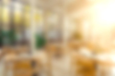 Sıcak ışıklandırma ve davetkar mobilyaların yer aldığı, şehir ortamında rahatlama ve sosyal etkinlikler için ideal, parlak ve havadar bir kafeterya..