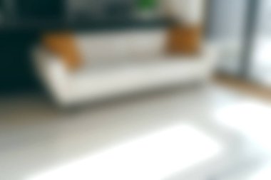 Parlak ve davetkar oturma odası modern bir kanepe dekoratif yastıklar ve büyük pencerelerden içeri akan sıcak doğal ışık ile rahat bir atmosfer yaratıyor..