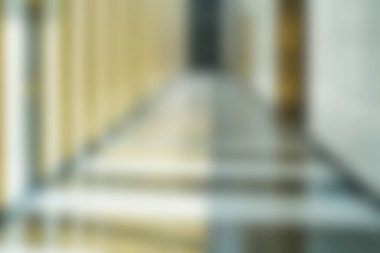 Bu görüntü, modern mimari bir koridorun bulanık bir görüntüsünü yakalıyor. Işık yansımaları ve zıt gölgeler sergiliyor. Huzur hissi uyandırıyor..