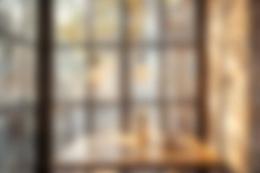 Sıcak ışıklandırma ve bulanık pencere manzaralı huzurlu bir ortam, rahatlama veya çalışma için mükemmel bir ortam yaratıyor..