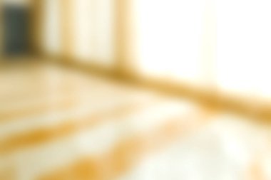 Yumuşak bulanık bir görüntü, doğal ışıkla aydınlatılmış sıcak, ahşap bir zemin sergiliyor, iç tasarım projeleri için mükemmel ve davetkar bir atmosfer yaratıyor..