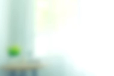 Yumuşak odaklı sakin bir iç mekan, pencereden yansıyan güneş ışığı, yeşil bitki ve minimalist dekor, sakin ve davetkar bir atmosfer yaratıyor..