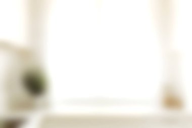 Saf perdelerin arasından süzülen yumuşak doğal ışığı gösteren sakin bir manzara, modern bir ev ortamında rahatlama ve rahatlama için sıcak ve davetkar bir atmosfer yaratır..