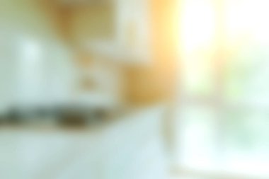 Parlak güneş ışığının pencerelerden içeri aktığı, yemek ve aile toplantıları için mükemmel sıcak ve davetkar bir atmosfer yaratan güzel tasarlanmış modern bir mutfak..