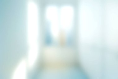 Doğal ışıkla aydınlatılan modern bir koridorun yumuşak bulanık görüntüsü zarif bir iç mekanda sakin ve davetkar bir atmosfer yaratıyor..