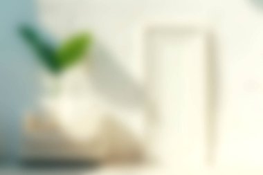 Yeşil bir yaprak, minimalist dekor ve doğal ışıktan oluşan modern bir çalışma alanının yumuşak bir odak noktası. Huzur ve yaratıcılık temaları için ideal.