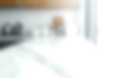 Parlak bir mutfak sahnesi. Bulanık bir mutfak tezgahı ve modern mutfak malzemeleri. Doğal ışıkla yıkanmış, yemek pişirmek ve toplamak için sıcak ve davetkar bir atmosfer yaratıyor..