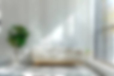 Parlak ve havadar bir oturma odası, doğal ışıkla modern bir dekor sergiliyor. Rahat alanda şık mobilyalar ve biraz yeşillik var..