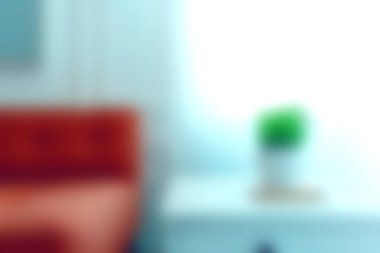 Rahat bir kanepe ve dekoratif bir bitki barındıran parlak ve cezbedici modern bir oturma odası dinlenmek için ideal bir ortam yaratıyor..