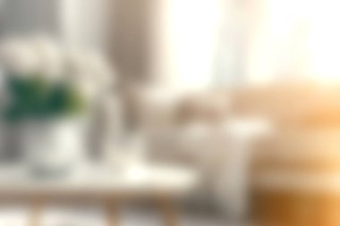 Zarif dokuları, nötr renkleri ve şık bir vazoda taze çiçekleri olan parlak ve davetkar bir oturma odası. Sıcak bir ortam yaratmak için mükemmel..