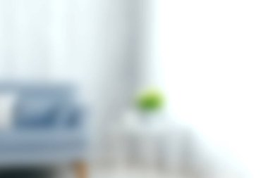 Konforlu bir kanepe ve küçük bir bitkinin yer aldığı sakin bir oturma odası. Yumuşak ışık, rahatlamak ve rahatlamak için mükemmel sıcak bir atmosfer yaratır..