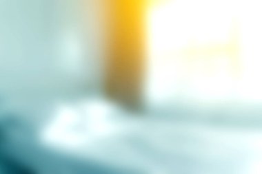 Parlak doğal ışıkla aydınlatılmış, minimalist dekorlarla rahatlatıcı ve davetkar bir atmosfer yaratan bir yatak odasının yumuşak odak görüntüsü..