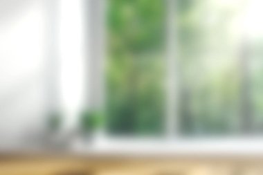 Doğal ışığı davet eden ve rahatlamak için mükemmel yemyeşil bir manzara sunan geniş pencereli sakin bir iç mekan..