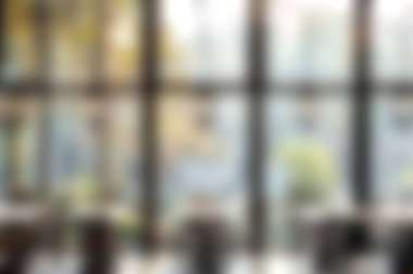 Parlak ve rahat bir restoran içi. Yeşil ağaçların manzarası ile doğal ışık alan büyük pencereleri var. Ortam yemek ve rahatlama için mükemmel..