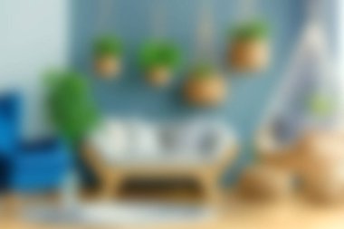 Bu resimde şık bir dekorun, yüzen bitki askılarının ve rahat mobilyaların bulunduğu rahat bir oturma odası, sıcak ve davetkar bir atmosfer yaratıyor..