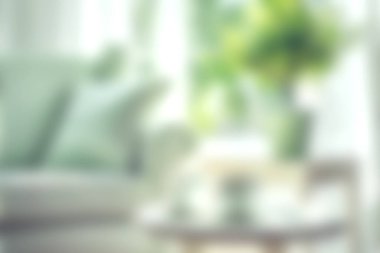 Yumuşak yeşil aksanları ve bol doğal ışığı olan rahat ve şık bir ortam yaratmak için mükemmel bir oturma odası..