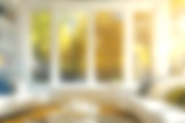 Bu resim, sonbahar renklerini güzel gösteren büyük pencereli rahat bir oturma odası yakalar, rahatlama ve rahatlama için sıcak ve davetkar bir atmosfer yaratır..