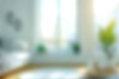 Bu resim, geniş doğal ışık, minimalist dekor ve rahatlamayı ve rahatlığı davet eden ferahlatıcı bir ambiyansı barındıran parlak ve havadar modern bir oturma odasını gösteriyor..