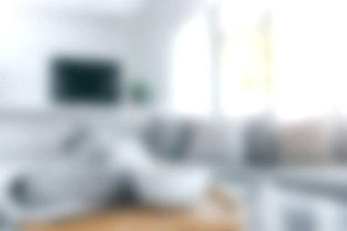 Parlak ve rahat bir oturma odasında minimalist dekorlar, doğal ışık ve davetkar mobilyalar sergileniyor. Tasarım rahatlamak için sakin bir atmosfer yaratıyor..