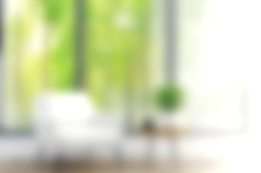 Parlak ve misafirperver bir oturma odasında beyaz bir sandalye, küçük bir masa ve yemyeşil, doğal ışıkla yıkanmış. Modern iç mekan için mükemmel..