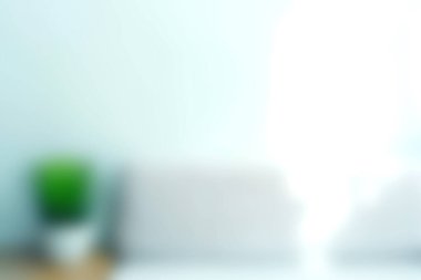 Minimalist bir iç mekan pencerenin içinden geçen yumuşak doğal ışığı yakalıyor, basit bir kapalı bitki tarafından tamamlanıyor, sakin ve sakinleştirici bir atmosfer yaratıyor..