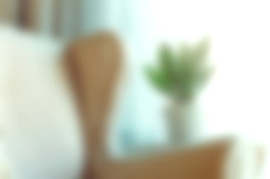 Bu görüntü, yumuşak bir koltuk ve parlak bir pencere tarafından yerleştirilmiş yeşil bir bitkinin yer aldığı rahat bir oturma odası ayarını yakalar. Rahatlamak için mükemmel ve davetkar bir atmosfer yaratır..