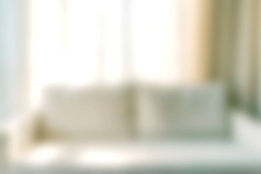 Bu görüntü, şık perdelerle aksanlı, iyi ışıklandırılmış bir oturma odasında rahat bir kanepenin odak noktasını yakalıyor. Sıcak atmosfer rahatlamayı ve rahatlamayı davet eder..