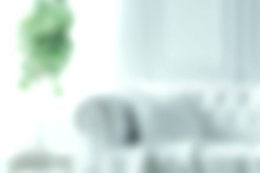 Zarif bir kanepe ve canlı yeşil bir bitkinin yer aldığı modern bir oturma odasını gösteren yumuşak odaklı bir görüntü. Parlak doğal ışık, sakin bir atmosfer yaratır..