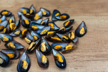 Tahta tabakta taze midye, domates ve maydanoz manzaralı.