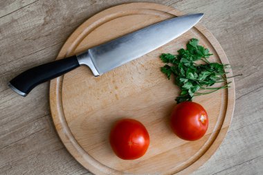 Pişirmeden önce sebze hazırlamak - domates, maydanoz, bıçak.