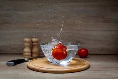 Taze Etki Salatalığı Domatesli bir kaseye sıçrıyor