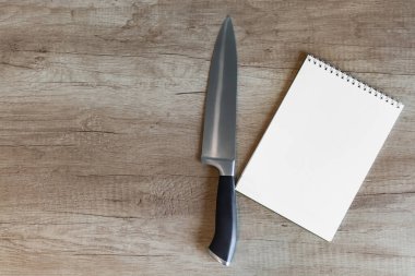 Ahşap yüzeyde defter ve mutfak bıçağı - kavram fikirleri, tarifler ve ilham