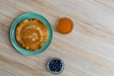 Tahta tabakta altın krep ve taze yaban mersini. Ev yapımı tatlı yemek konsepti, kahvaltı, brunch veya tatlı için mükemmel. Kırsal yemek fotoğrafçılığı.