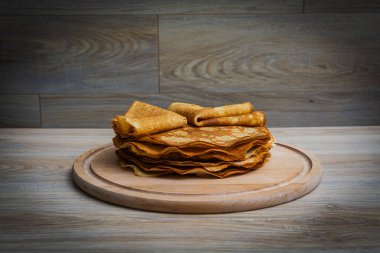 Tahta tabakta altın krep ve taze yaban mersini. Ev yapımı tatlı yemek konsepti, kahvaltı, brunch veya tatlı için mükemmel. Kırsal yemek fotoğrafçılığı.