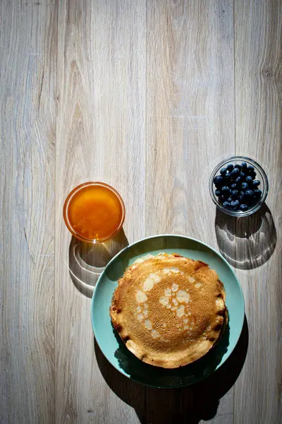 Tahta tabakta altın krep ve taze yaban mersini. Ev yapımı tatlı yemek konsepti, kahvaltı, brunch veya tatlı için mükemmel. Kırsal yemek fotoğrafçılığı.
