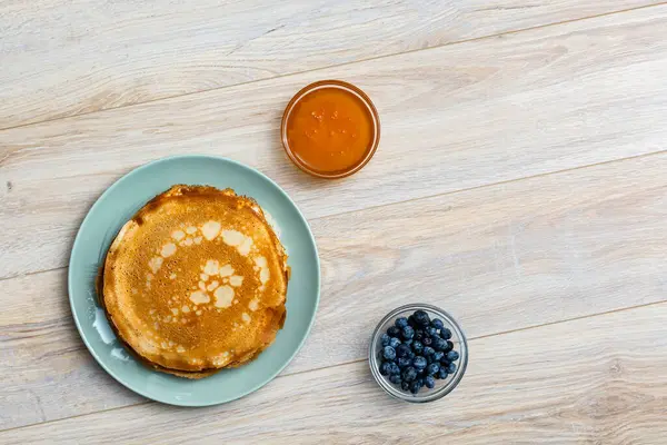 Tahta tabakta altın krep ve taze yaban mersini. Ev yapımı tatlı yemek konsepti, kahvaltı, brunch veya tatlı için mükemmel. Kırsal yemek fotoğrafçılığı.