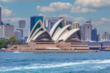 Simgesel Sydney Opera Evi 'nin panoramik manzarası. Arka planda CBD silueti, gökyüzü, körfezden gelen turkuaz sular. Sydneys Central Business District 'in modern silueti. Avustralya 'nın en tanınan şehri. Dünya Mirası Alanı. NSW 'de. Sanat.