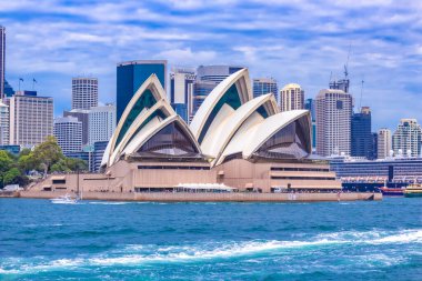 Simgesel Sydney Opera Evi 'nin panoramik manzarası. Arka planda CBD silueti, gökyüzü, körfezden gelen turkuaz sular. Sydneys Central Business District 'in modern silueti. Avustralya 'nın en tanınan şehri. Dünya Mirası Alanı. NSW 'de. Sanat.
