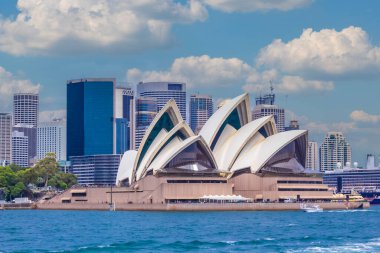 Simgesel Sydney Opera Evi 'nin panoramik manzarası. Arka planda CBD silueti, gökyüzü, körfezden gelen turkuaz sular. Sydneys Central Business District 'in modern silueti. Avustralya 'nın en tanınan şehri. Dünya Mirası Alanı. NSW 'de. Sanat.