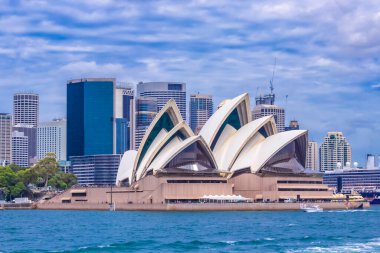 Simgesel Sydney Opera Evi 'nin panoramik manzarası. Arka planda CBD silueti, gökyüzü, körfezden gelen turkuaz sular. Sydneys Central Business District 'in modern silueti. Avustralya 'nın en tanınan şehri. Dünya Mirası Alanı. NSW 'de. Sanat.
