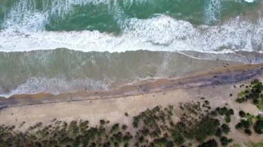 Büyük dalgalı bir deniz manzarası kumu ezdi..